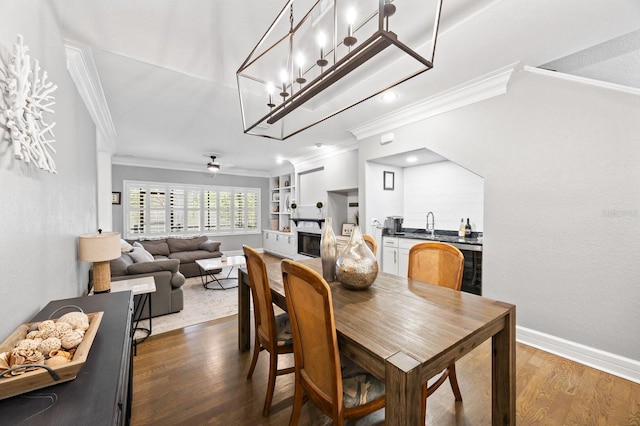 9722 Tiffany Oaks Ln, Tampa, FL 33612 - dining space featuring ornamental molding, dark wood-style flooring, a fireplace, baseboards, and a ceiling fan