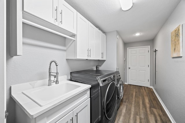 9722 Tiffany Oaks Ln, Tampa, FL 33612 - washroom featuring washing machine and clothes dryer, dark wood-style floors, cabinet space, baseboards, and a textured wall