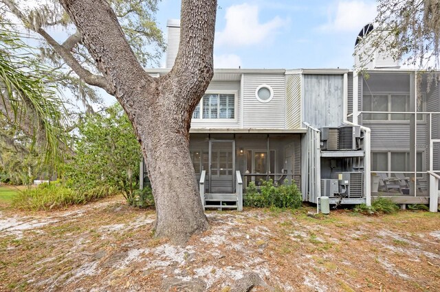 9722 Tiffany Oaks Ln, Tampa, FL 33612 - rear view of house with a sunroom, a chimney, and central AC