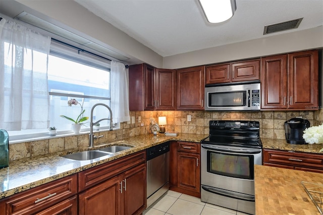 2012 Scotland Dr, Clearwater, FL 33763 - kitchen with stainless steel appliances, a sink, tasteful backsplash, light tile patterned floors, and light stone counters