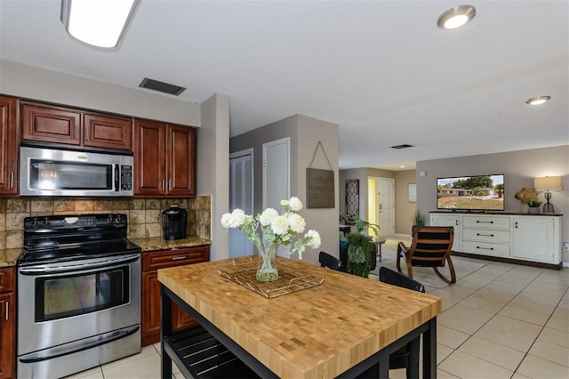 2012 Scotland Dr, Clearwater, FL 33763 - kitchen with stainless steel appliances, light tile patterned floors, backsplash, and light stone counters