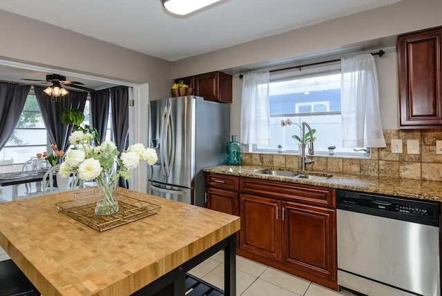 2012 Scotland Dr, Clearwater, FL 33763 - kitchen featuring stainless steel appliances, a sink, light tile patterned floors, and light stone countertops