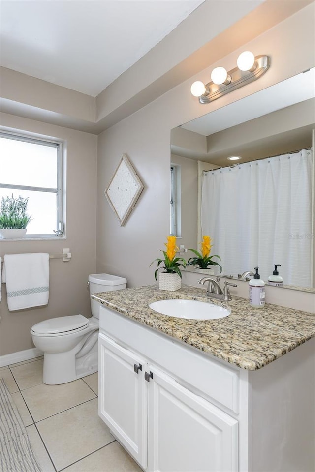 2012 Scotland Dr, Clearwater, FL 33763 - bathroom with toilet, vanity, tile patterned flooring, and baseboards