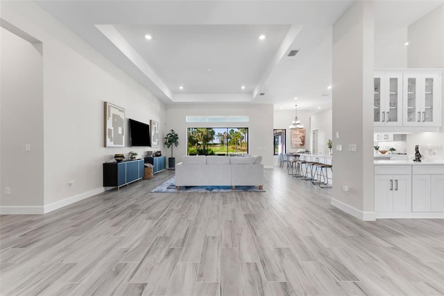 3888 Santa Caterina Blvd, Bradenton, FL 34211 - living room featuring a tray ceiling, light wood-style flooring, and recessed lighting