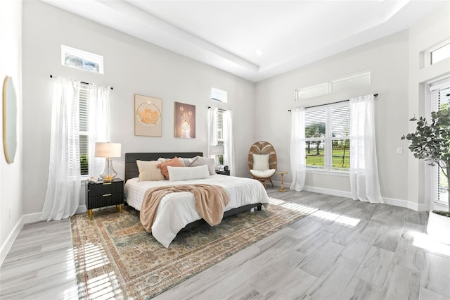 3888 Santa Caterina Blvd, Bradenton, FL 34211 - bedroom featuring a tray ceiling, light wood-style floors, and a high ceiling
