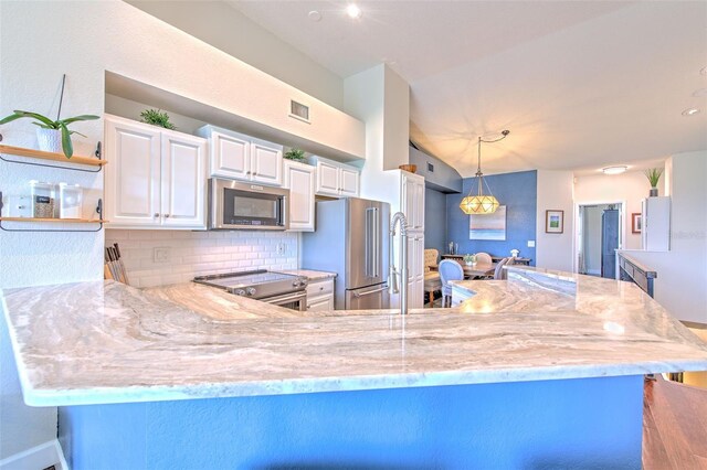 1111 Normandy Trace Rd Unit 1111, Tampa, FL 33602 - kitchen featuring stainless steel appliances, decorative backsplash, white cabinets, light stone counters, and lofted ceiling