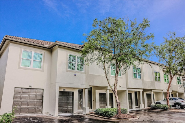 1111 Normandy Trace Rd Unit 1111, Tampa, FL 33602 - view of property featuring a garage, stucco siding, and a tiled roof