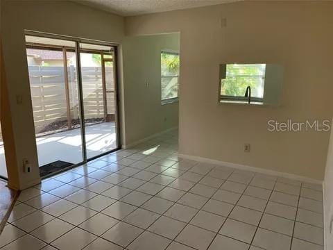 2720 Sand Hollow Ct Unit 156A, Clearwater, FL 33761 - empty room featuring baseboards, light tile patterned floors, and a textured ceiling