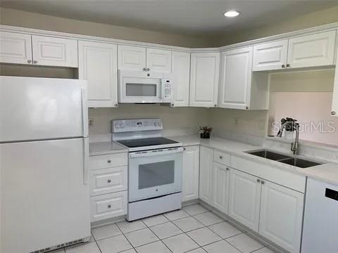 2720 Sand Hollow Ct Unit 156A, Clearwater, FL 33761 - kitchen with white appliances, a sink, white cabinets, light countertops, and recessed lighting