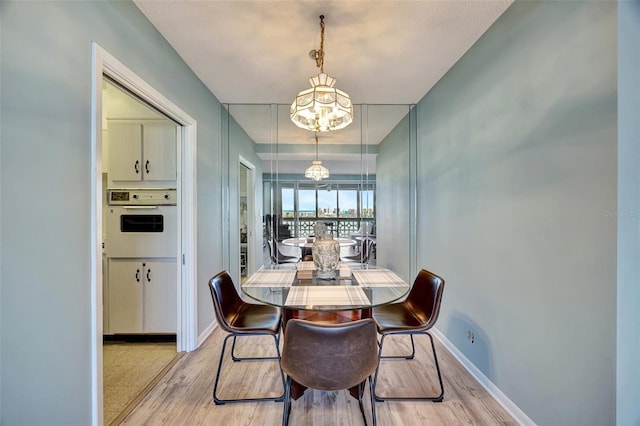 31 Island Way Unit 1403, Clearwater Beach, FL 33767 - dining area with light wood-type flooring, baseboards, and a chandelier