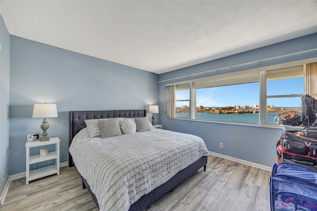 31 Island Way Unit 1403, Clearwater Beach, FL 33767 - bedroom with wood finished floors, baseboards, and a water view