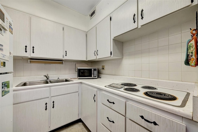 31 Island Way Unit 1403, Clearwater Beach, FL 33767 - kitchen with a sink, white appliances, light countertops, and decorative backsplash