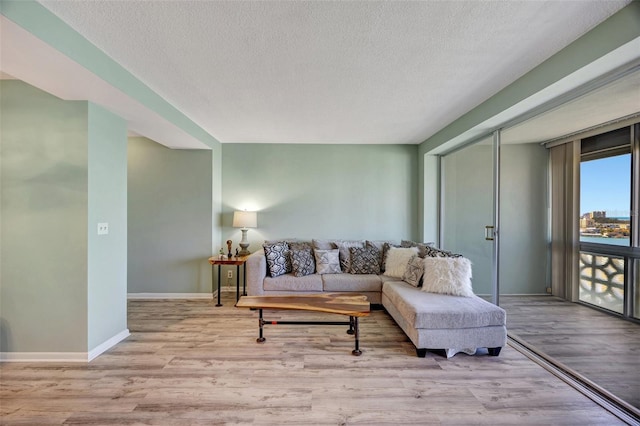 31 Island Way Unit 1403, Clearwater Beach, FL 33767 - living area with wood finished floors, a textured ceiling, and baseboards