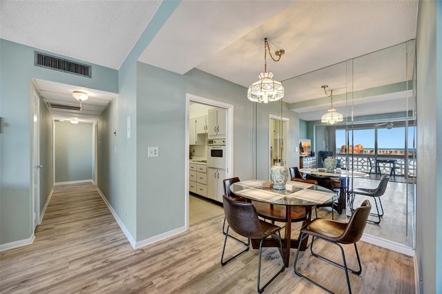 31 Island Way Unit 1403, Clearwater Beach, FL 33767 - dining area featuring light wood-style floors, baseboards, and a chandelier