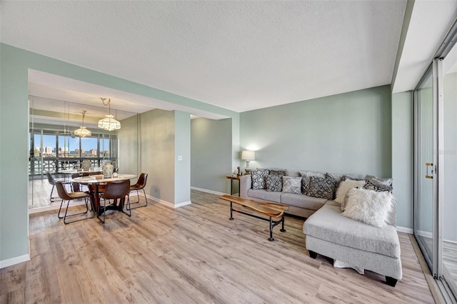 31 Island Way Unit 1403, Clearwater Beach, FL 33767 - living area with wood finished floors, baseboards, a textured ceiling, and a chandelier