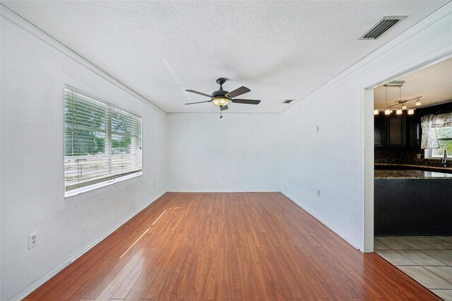 503 Holt Cir, Winter Haven, FL 33880 - unfurnished room featuring wood finished floors, a textured ceiling, a ceiling fan, and crown molding