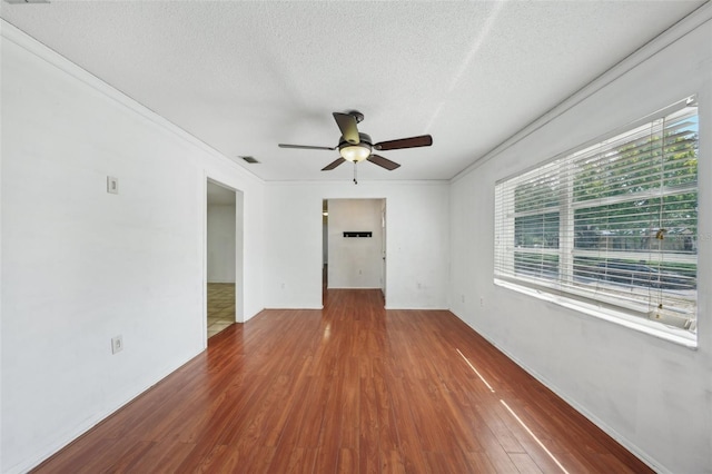 503 Holt Cir, Winter Haven, FL 33880 - unfurnished room featuring wood finished floors, ceiling fan, plenty of natural light, a textured ceiling, and ornamental molding