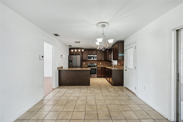 503 Holt Cir, Winter Haven, FL 33880 - kitchen featuring appliances with stainless steel finishes, dark brown cabinetry, a chandelier, backsplash, and a peninsula