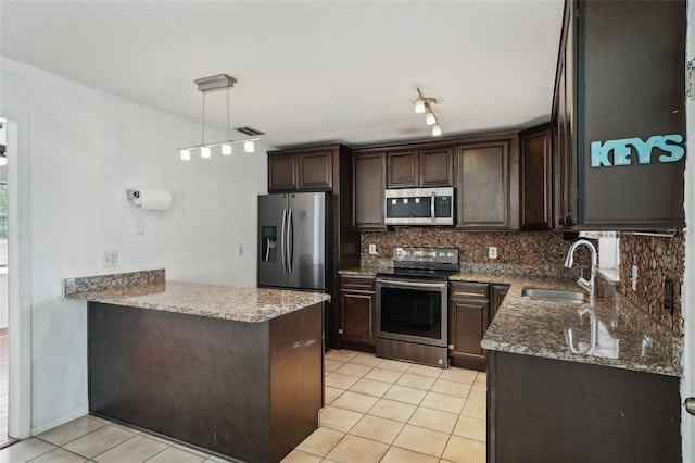 503 Holt Cir, Winter Haven, FL 33880 - kitchen with appliances with stainless steel finishes, a sink, dark brown cabinetry, tasteful backsplash, and light tile patterned floors