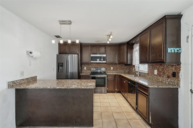 503 Holt Cir, Winter Haven, FL 33880 - kitchen with appliances with stainless steel finishes, a sink, dark brown cabinets, decorative backsplash, and light stone countertops