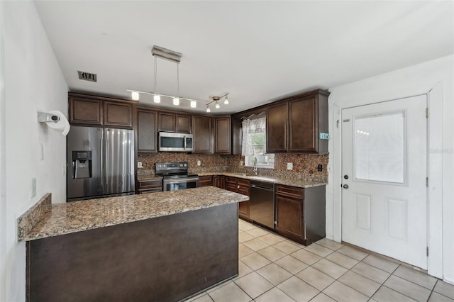 503 Holt Cir, Winter Haven, FL 33880 - kitchen with stainless steel appliances, dark brown cabinets, a peninsula, decorative backsplash, and light stone countertops