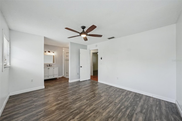 503 Holt Cir, Winter Haven, FL 33880 - unfurnished bedroom with dark wood-style floors, baseboards, a sink, connected bathroom, and a ceiling fan