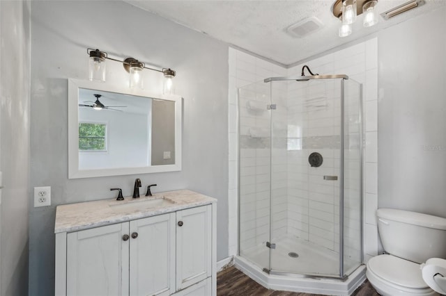 503 Holt Cir, Winter Haven, FL 33880 - bathroom featuring a stall shower, vanity, toilet, wood finished floors, and a textured ceiling