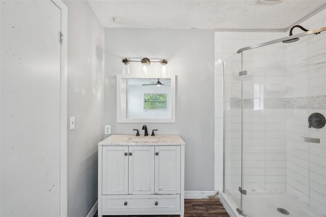 503 Holt Cir, Winter Haven, FL 33880 - bathroom with a stall shower, a ceiling fan, wood finished floors, and vanity