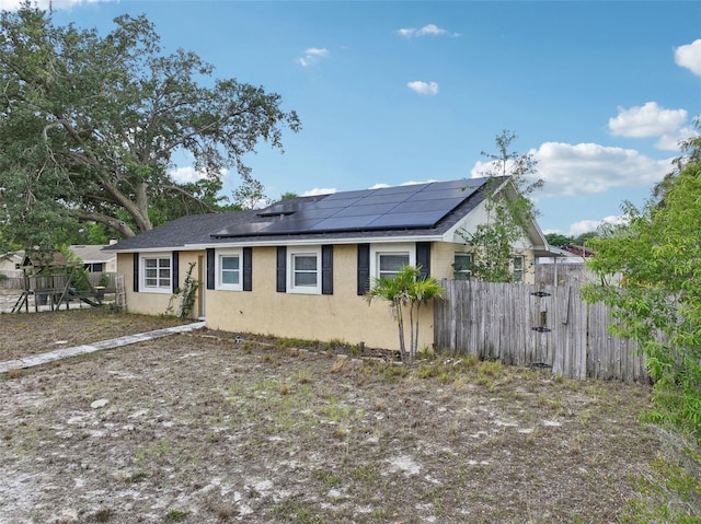 503 Holt Cir, Winter Haven, FL 33880 - ranch-style home with solar panels, stucco siding, fence, and roof with shingles