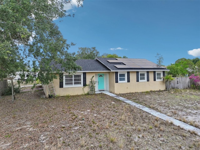 503 Holt Cir, Winter Haven, FL 33880 - ranch-style house featuring stucco siding, roof mounted solar panels, fence, and roof with shingles