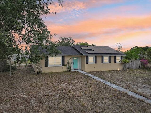 503 Holt Cir, Winter Haven, FL 33880 - ranch-style home with stucco siding, roof mounted solar panels, fence, and roof with shingles