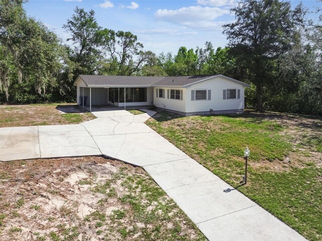 11409 Spring Hill Dr, Spring Hill, FL 34609 - single story home featuring a front yard, concrete driveway, a carport, and view of scattered trees