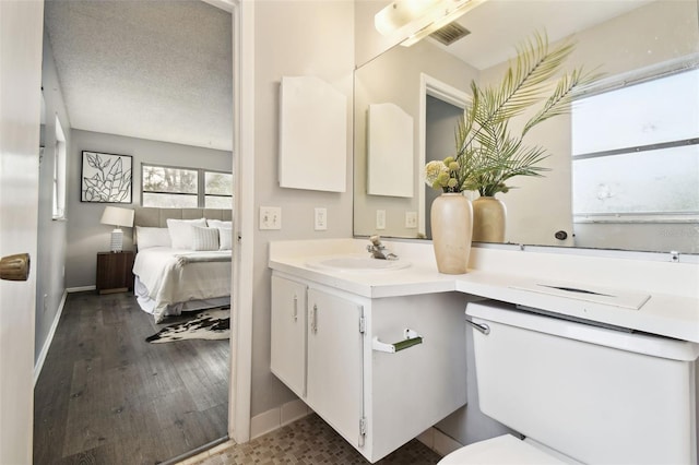 11409 Spring Hill Dr, Spring Hill, FL 34609 - bathroom featuring vanity, baseboards, toilet, and wood finished floors