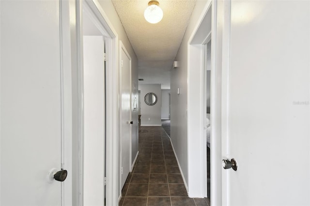 11409 Spring Hill Dr, Spring Hill, FL 34609 - corridor with a textured ceiling, dark tile patterned floors, and baseboards