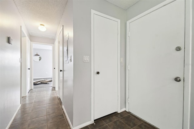 11409 Spring Hill Dr, Spring Hill, FL 34609 - hallway featuring a textured ceiling, dark tile patterned floors, and baseboards