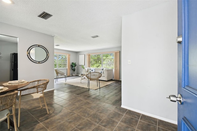 11409 Spring Hill Dr, Spring Hill, FL 34609 - dining space featuring baseboards, a textured ceiling, and dark tile patterned floors