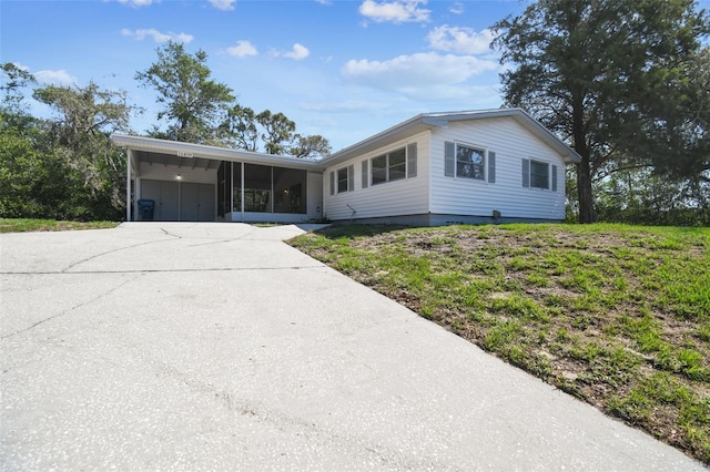 11409 Spring Hill Dr, Spring Hill, FL 34609 - single story home with a sunroom, an attached carport, and concrete driveway