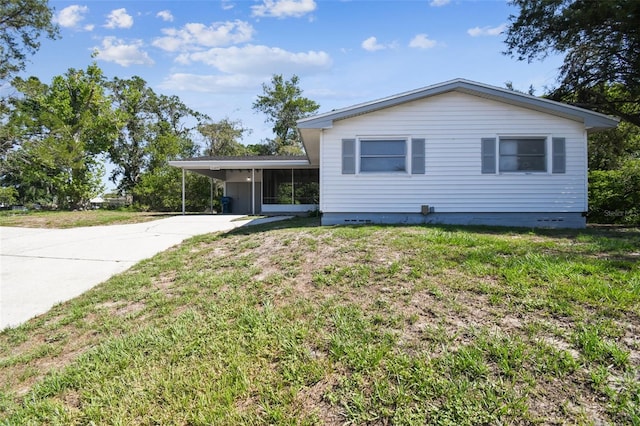 11409 Spring Hill Dr, Spring Hill, FL 34609 - view of front of home with concrete driveway, an attached carport, a sunroom, and a front yard