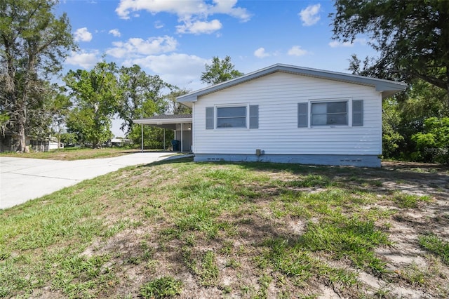 11409 Spring Hill Dr, Spring Hill, FL 34609 - view of side of home featuring driveway, an attached carport, and a yard