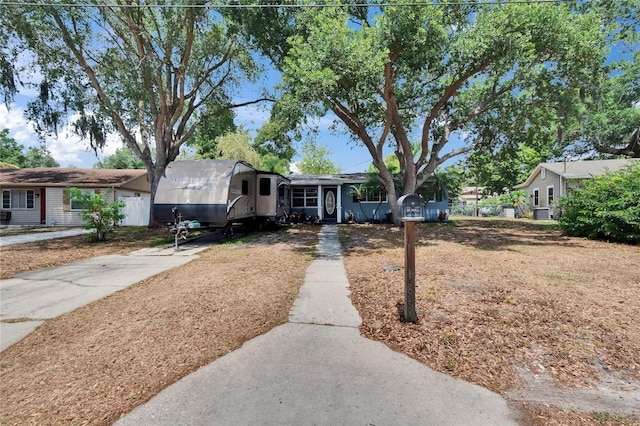 ranch-style house featuring driveway and fence