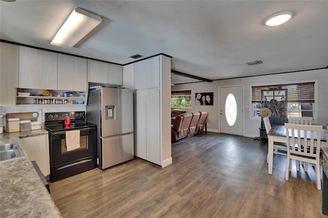 kitchen featuring black range with electric stovetop, stainless steel refrigerator with ice dispenser, light wood-type flooring, light countertops, and a sink