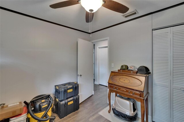 misc room featuring wood finished floors, ceiling fan, and ornamental molding
