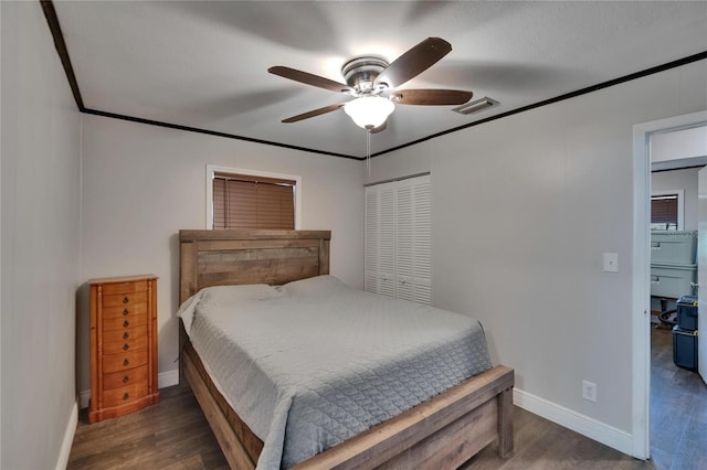 bedroom featuring wood finished floors, baseboards, a closet, a ceiling fan, and ornamental molding