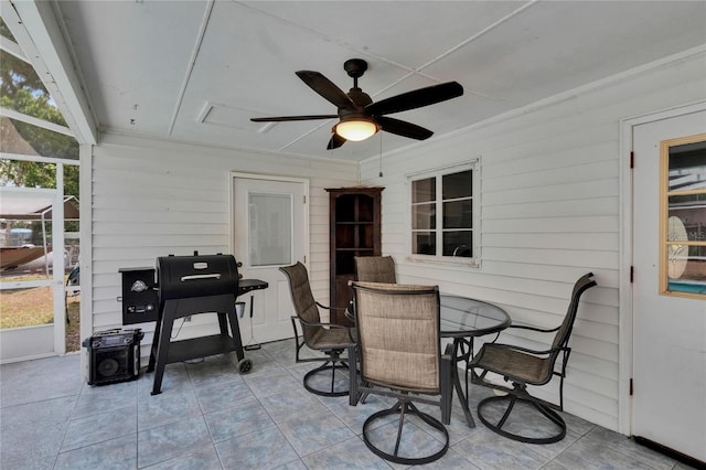 view of patio / terrace featuring a ceiling fan, glass enclosure, and outdoor dining space