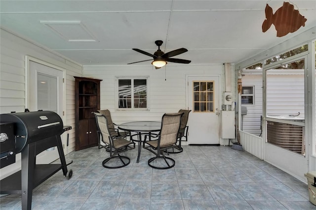 sunroom with a ceiling fan and outdoor dining area