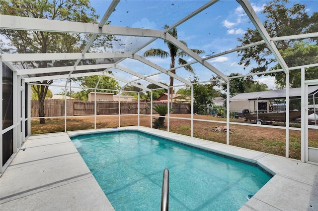 view of swimming pool featuring glass enclosure, fence, and a patio area
