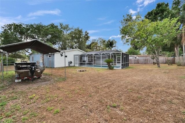 back of house featuring a detached carport and a lanai