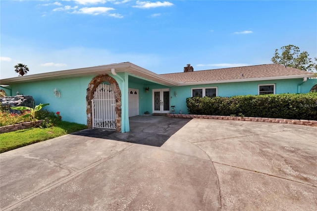 6530 Manila Palm Way, Apollo Beach, FL 33572 - ranch-style house with french doors, an attached garage, a chimney, stucco siding, and driveway