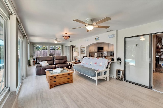 6530 Manila Palm Way, Apollo Beach, FL 33572 - bedroom with arched walkways, light wood-style floors, and a ceiling fan
