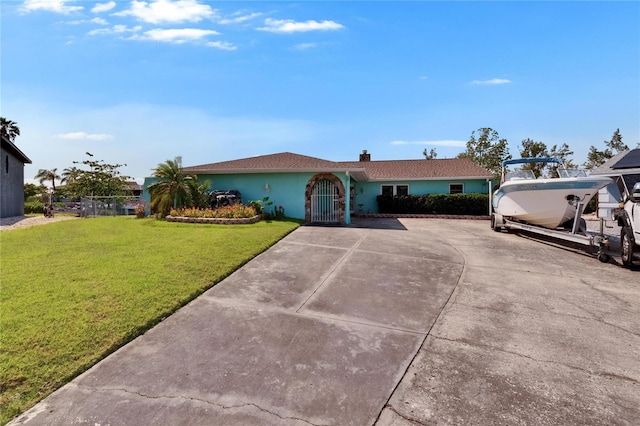 6530 Manila Palm Way, Apollo Beach, FL 33572 - ranch-style home with a front lawn, stucco siding, concrete driveway, and a chimney